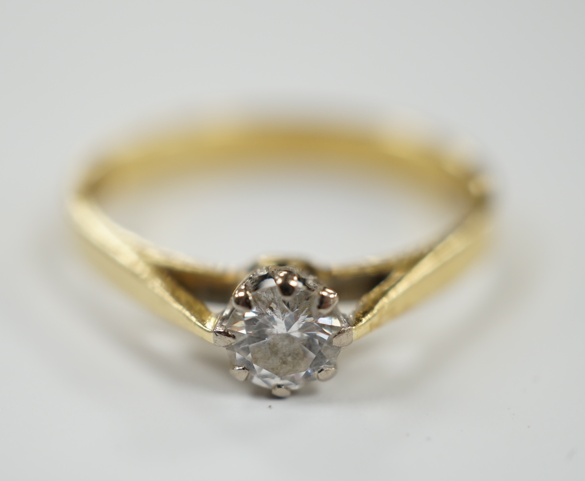 A modern 18ct gold and solitaire diamond set ring, size L/M, gross weight 2.4 grams.
